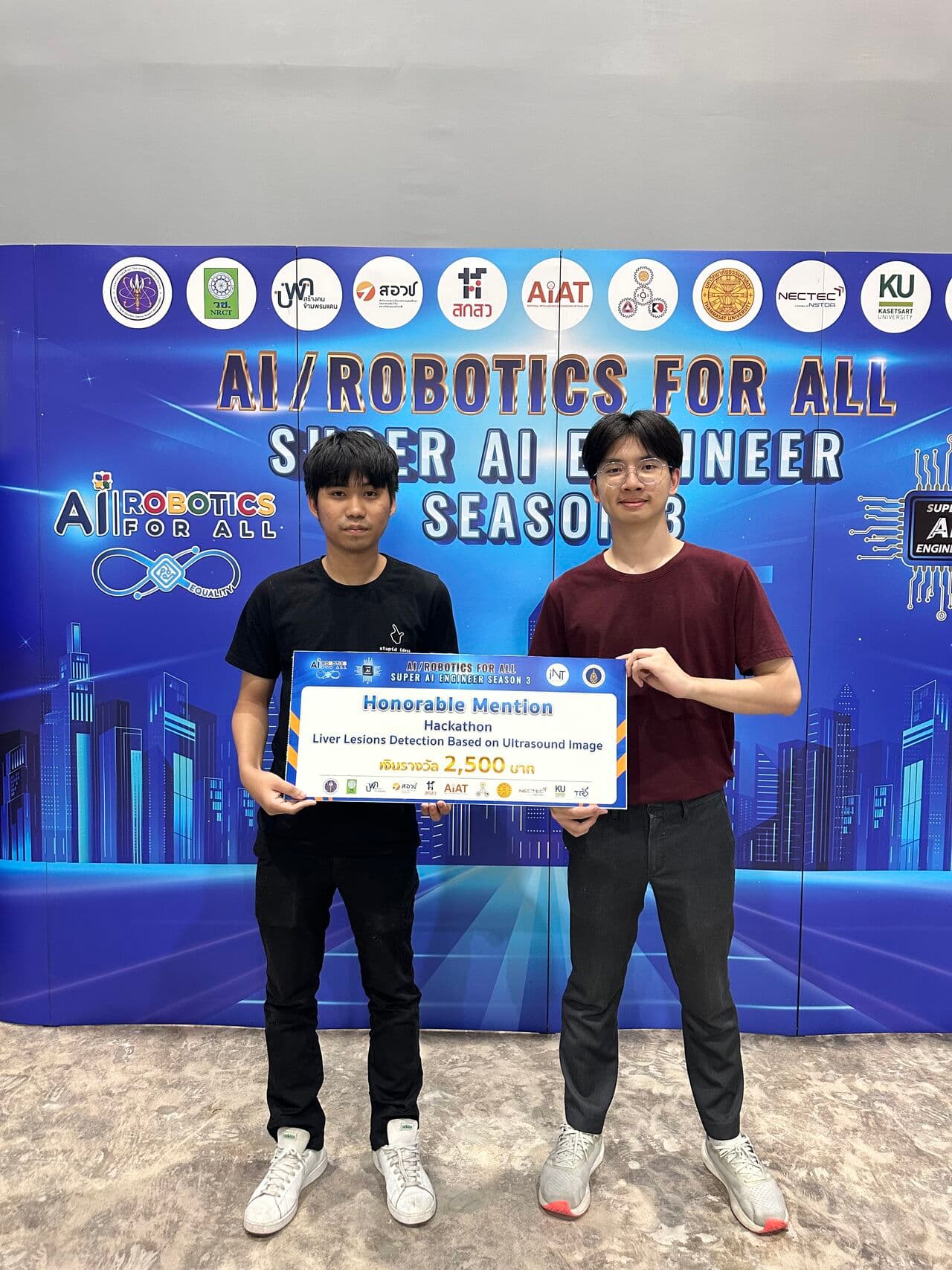 Thanyapisit and teammate holding an honorable mention award for liver lesions detection